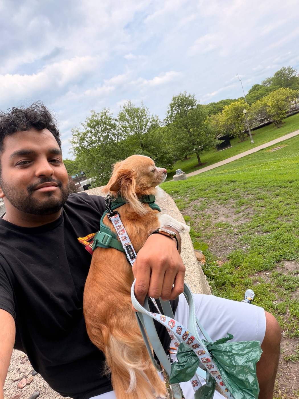 Sai in a Chicago park holding a small dog